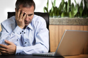 Frustrated businessman at laptop.