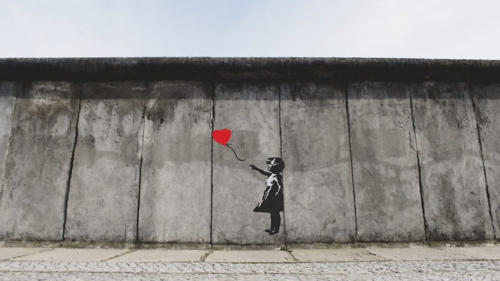 Berliner Mauer mit Kind das Herzluftballon verliert