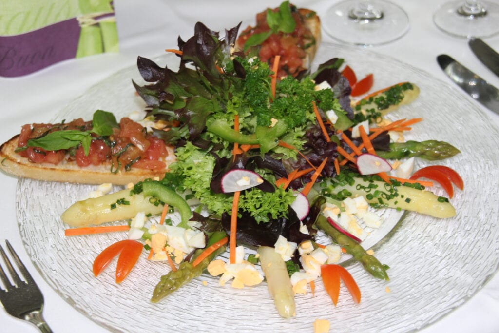 Marinierter Stangenspargel in Kräutervinaigrette mit Gehäck vom Ei an buntem Salatbouqette mit Tomatenbruschetta