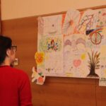Menschen betrachten gemaltes Bild an Wand