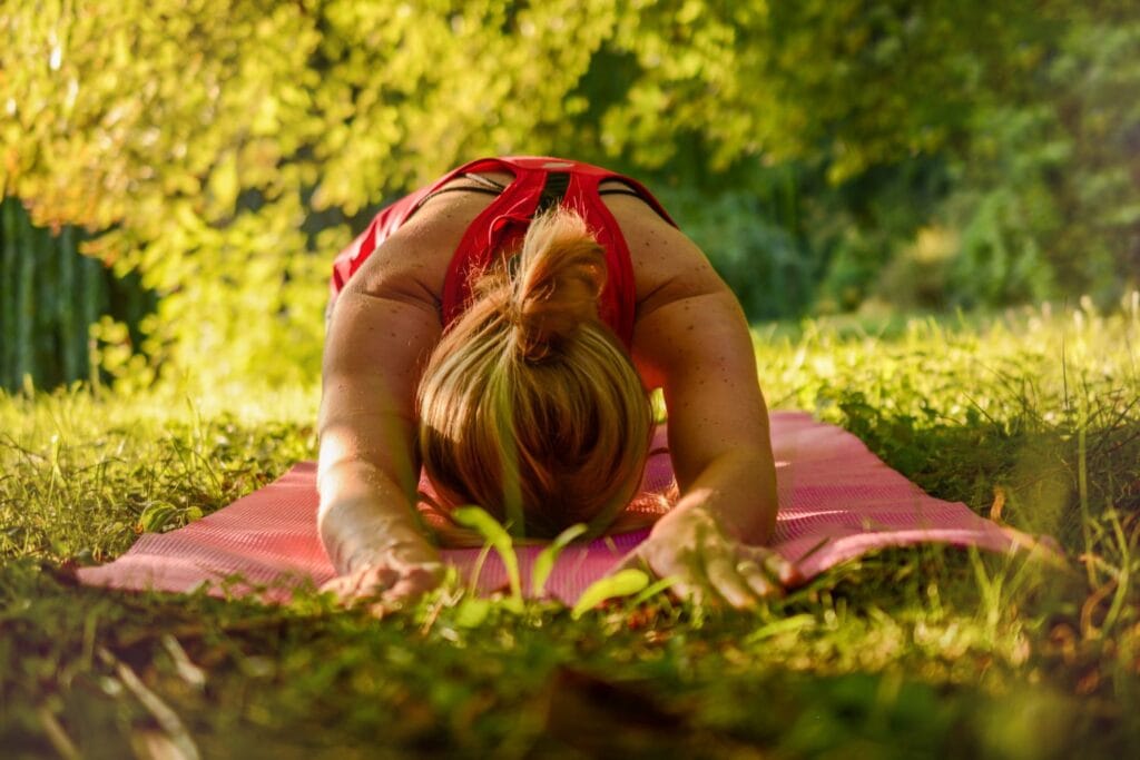 Frau macht Yoga auf einer Wiese