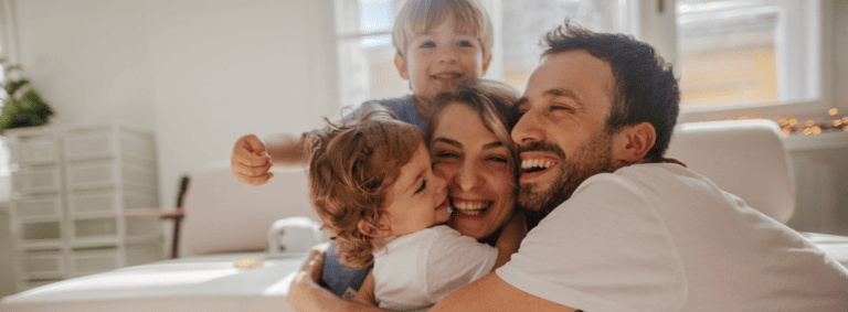 Header: Systemische Familientherapie zeigt eine glückliche sich umarmende Familie