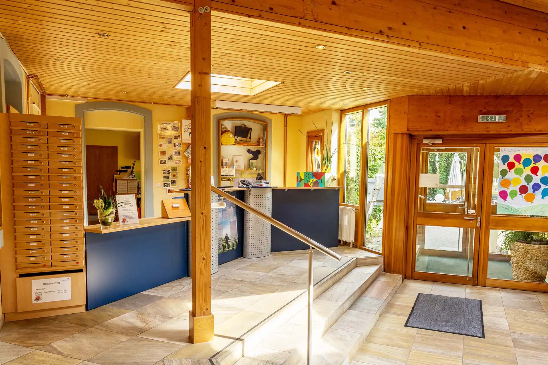 Heller Eingangsbereich der Fachklinik Heiligenfeld mit Rezeption und Blick in den Innenhof.