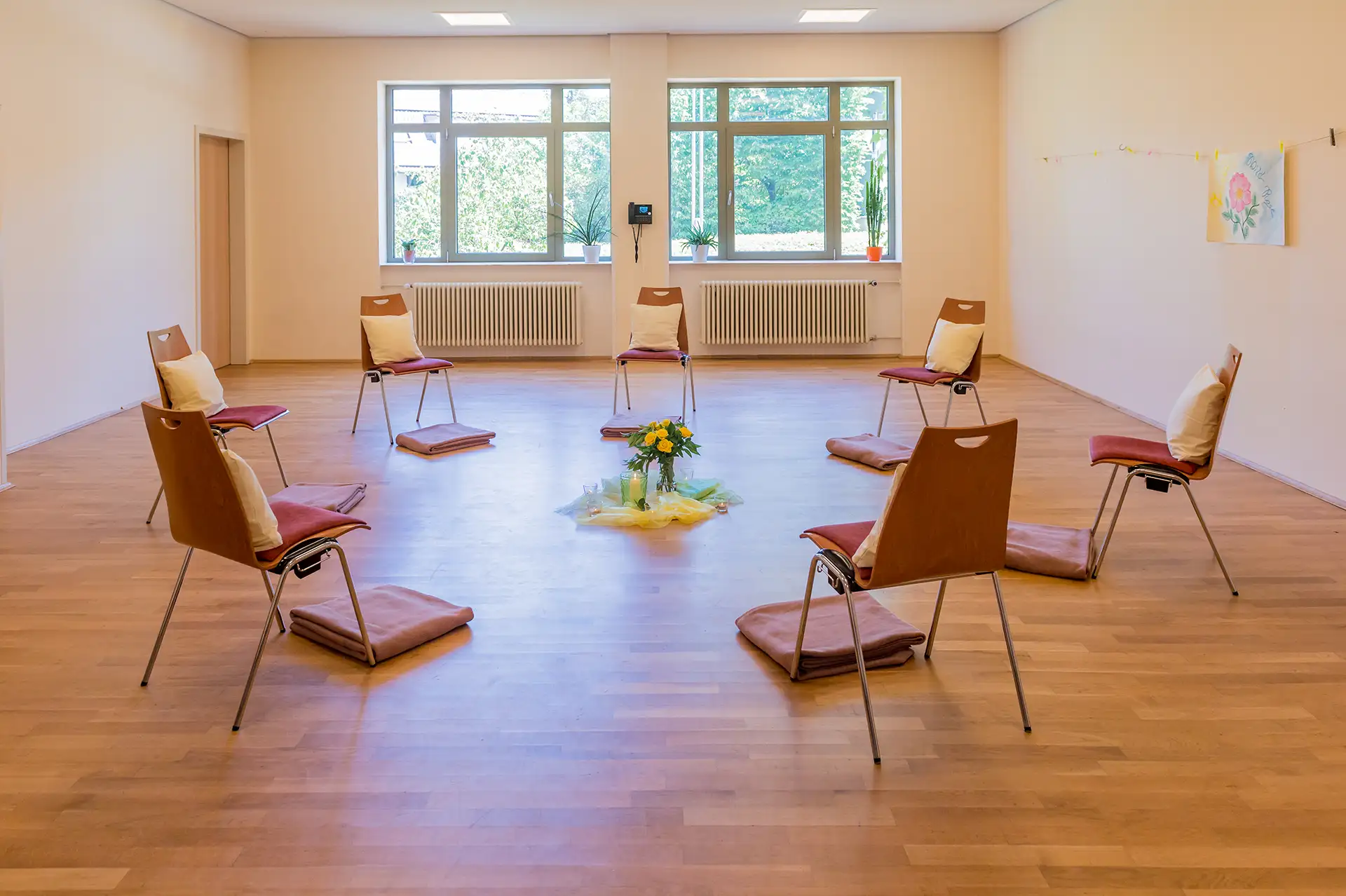 Therapieraum mit Stuehlen im Kreis, Dekoration in der Mitte.