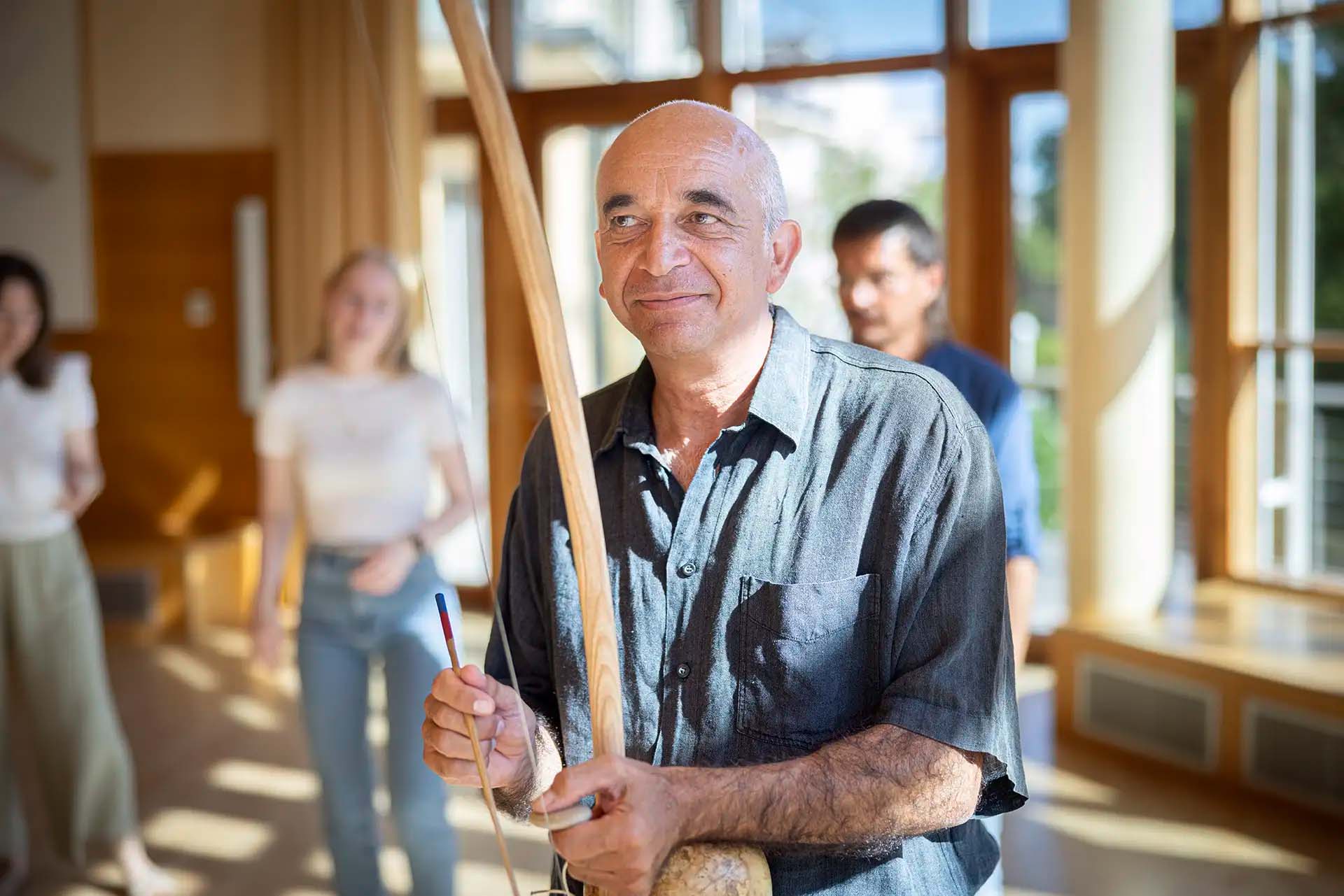 Leiter einer Gruppenmusiktherapie, spielt ein traditionelles Saiteninstrument.
