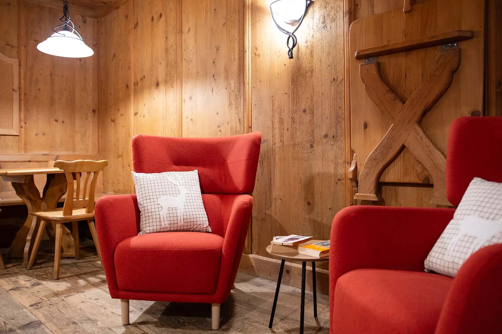 Gemuetliche Sitzecke mit roten Sesseln und rustikaler Einrichtung.