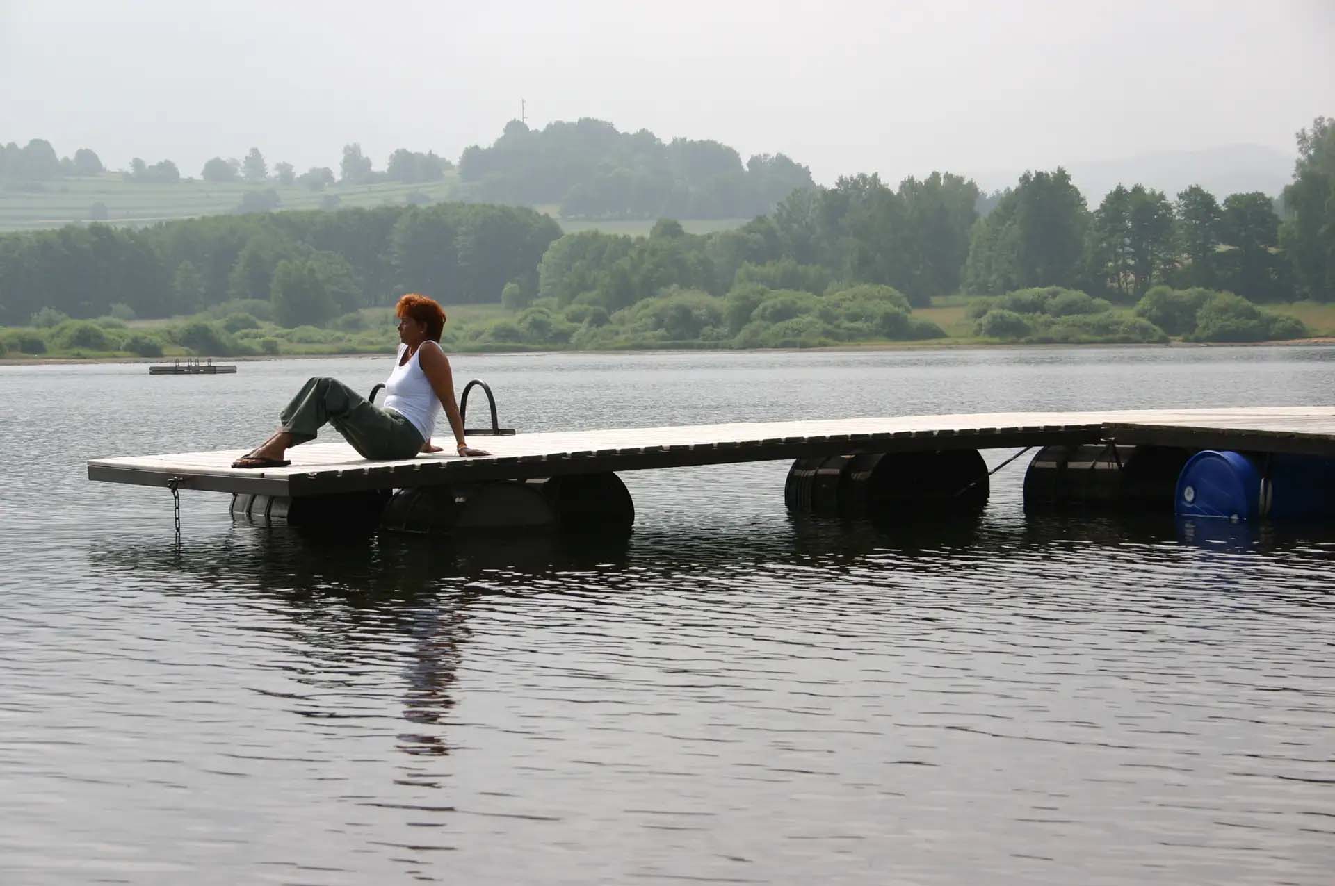Frau entspannt auf Steg am ruhigen See.