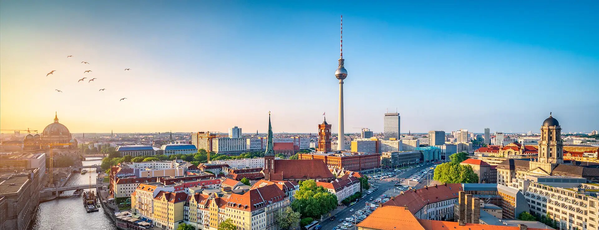 Panorama von Berlin bei Sonnenuntergang, mit Blick auf den Berliner Dom und den Fernsehturm.