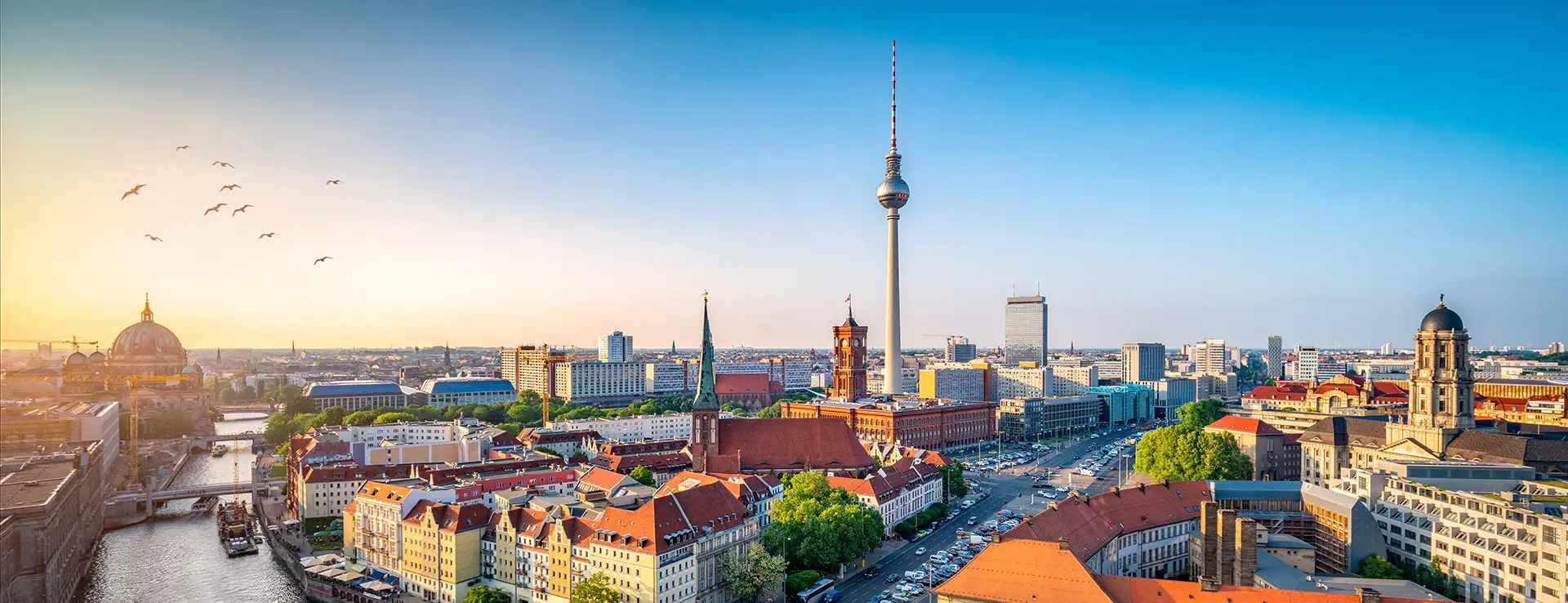 Panorama von Berlin bei Sonnenuntergang, mit Blick auf den Berliner Dom und den Fernsehturm.