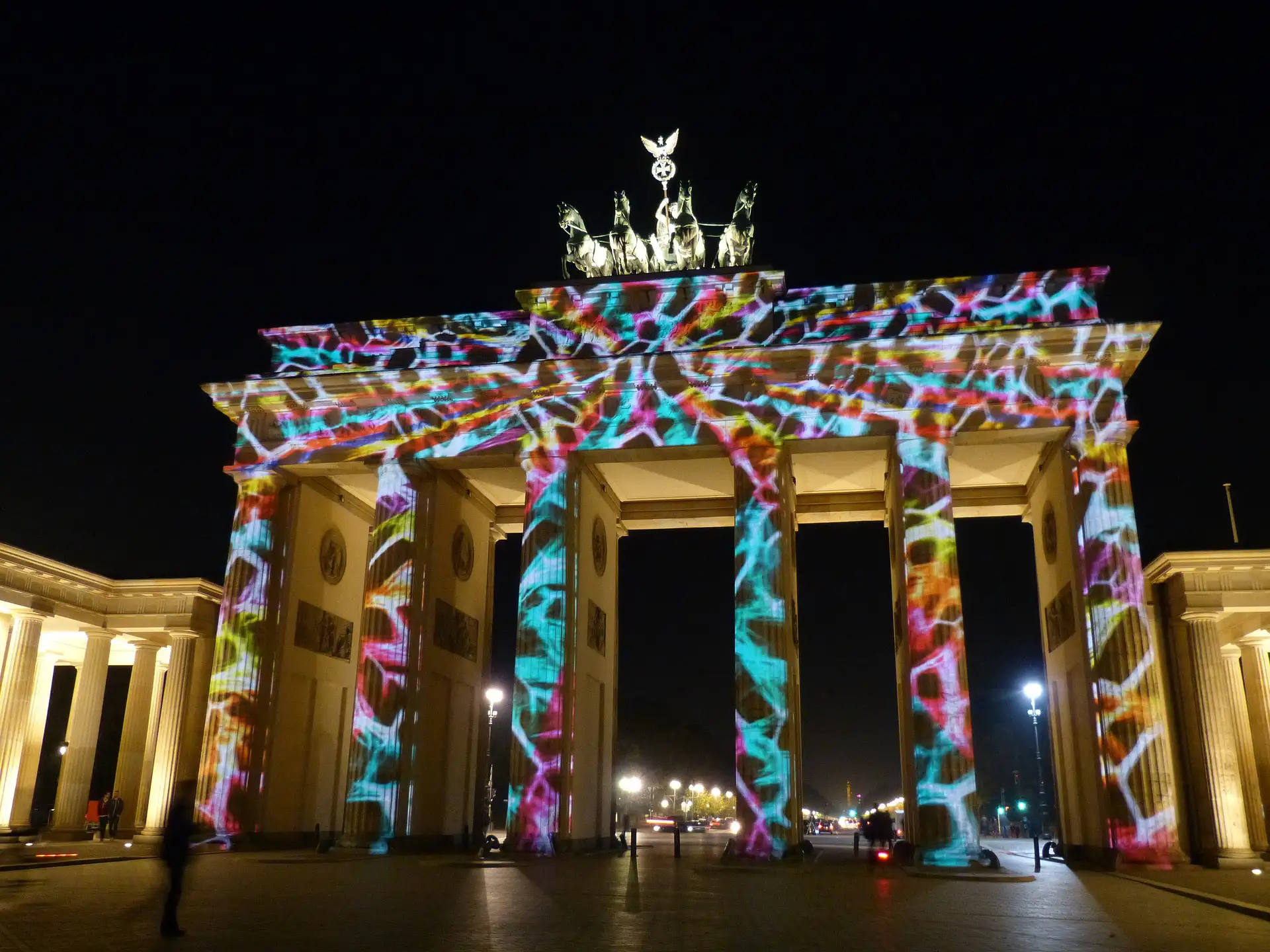 Das Brandenburger Tor erleuchtet mit farbenfrohen Lichtprojektionen bei nächtlichem Festival.