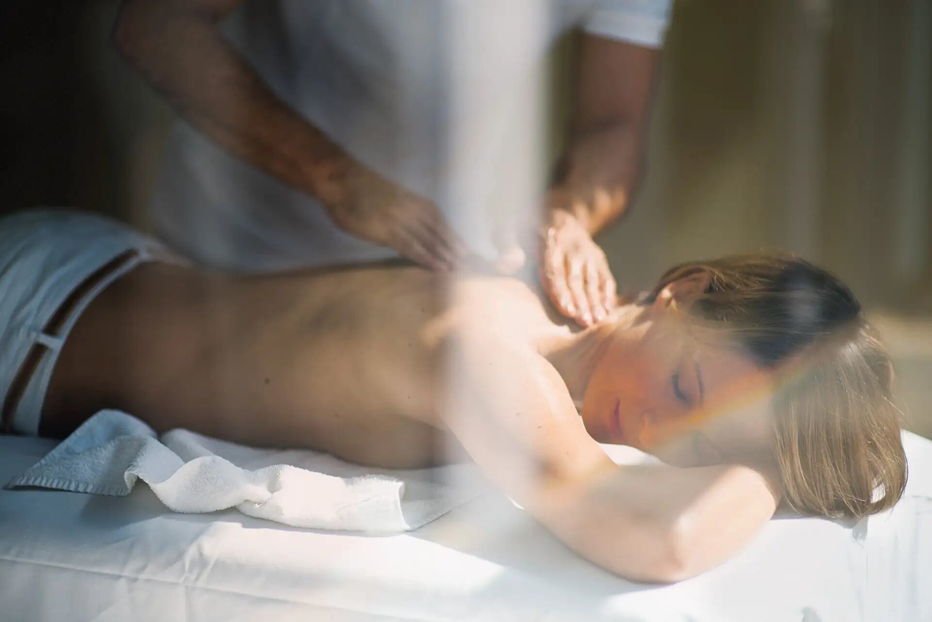 Person genießt eine entspannende Rückenmassage in ruhiger Atmosphäre.