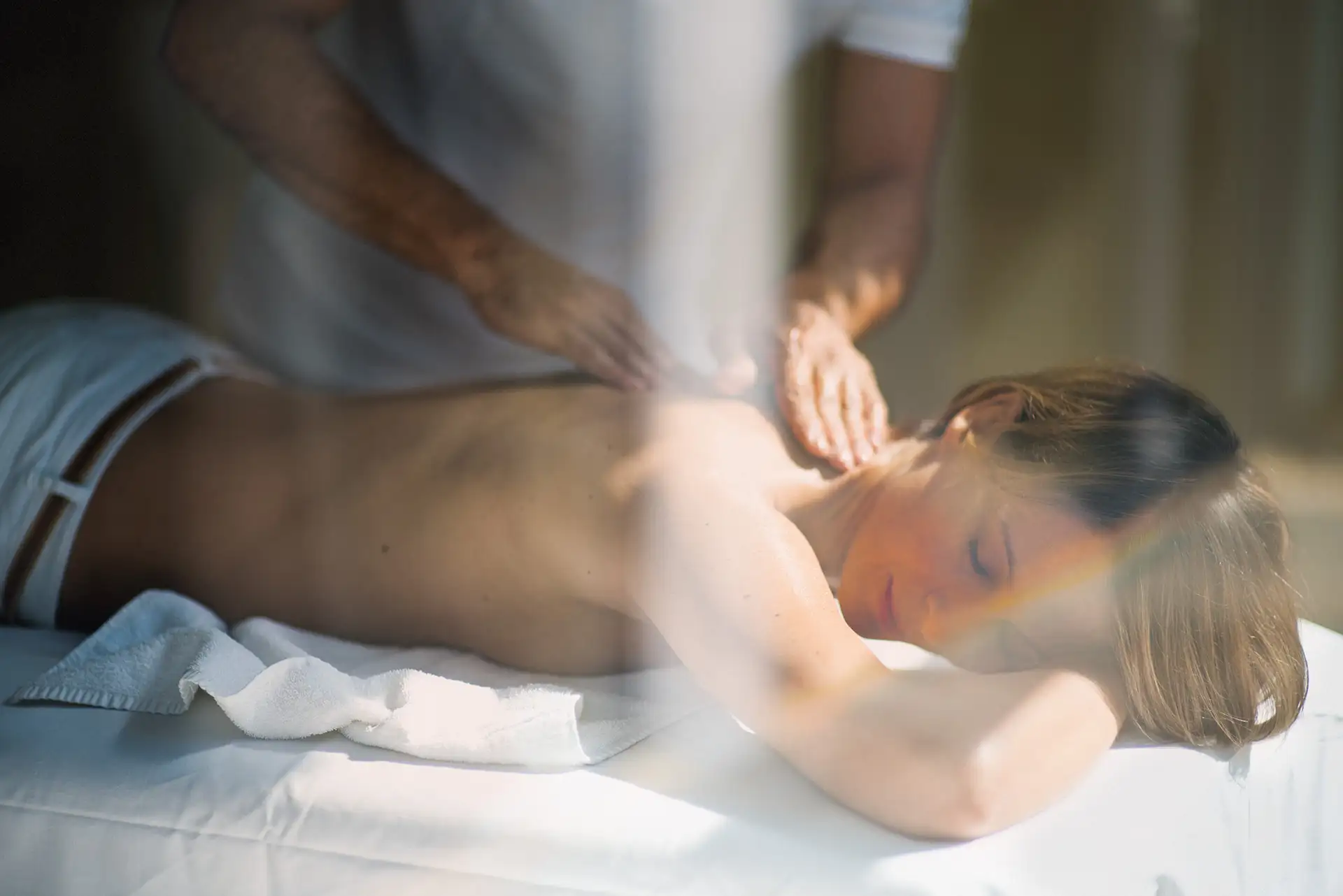 Person genießt eine entspannende Rückenmassage in ruhiger Atmosphäre.