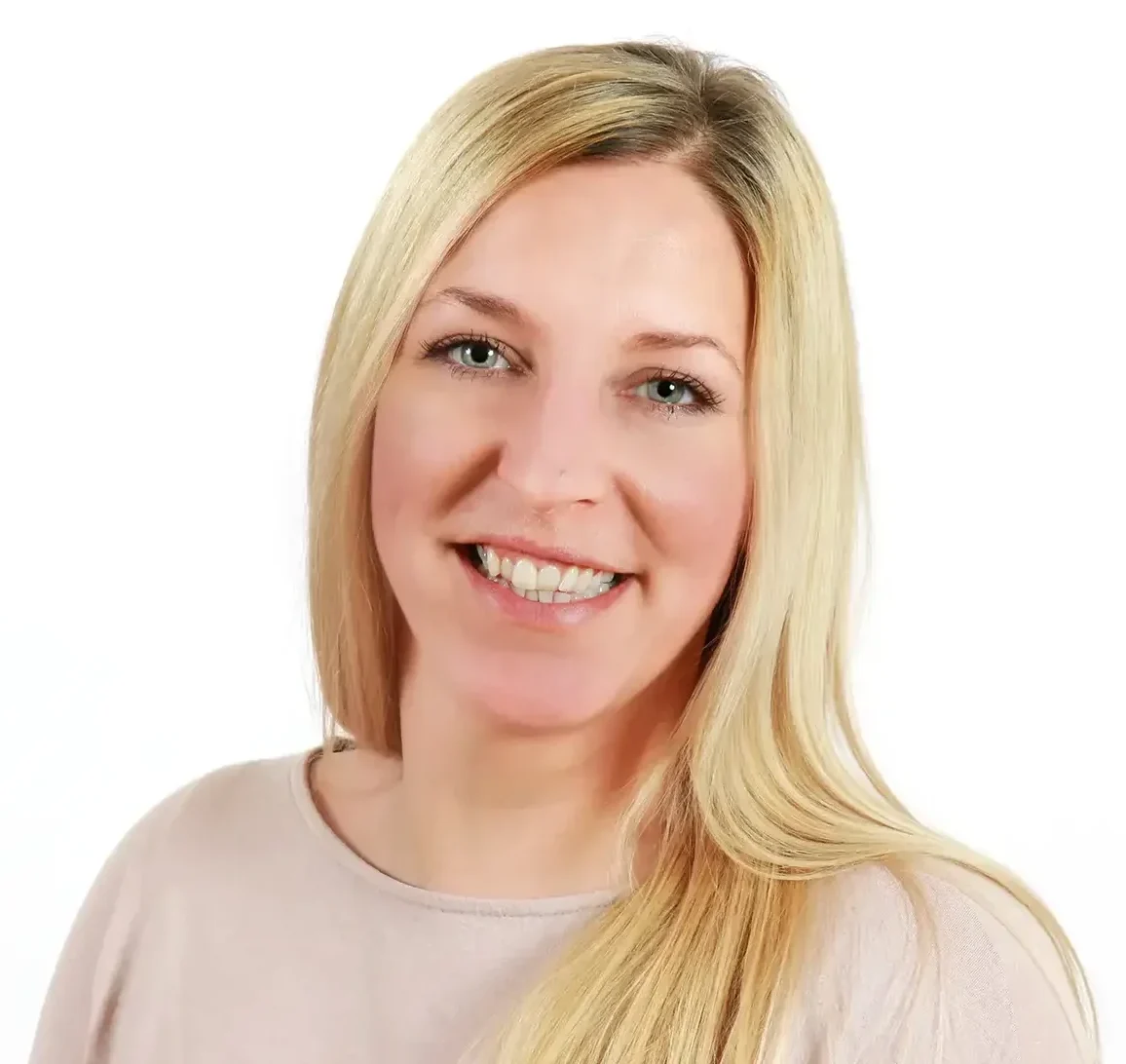 Frau mit blonden langen Haaren lächelt freundlich