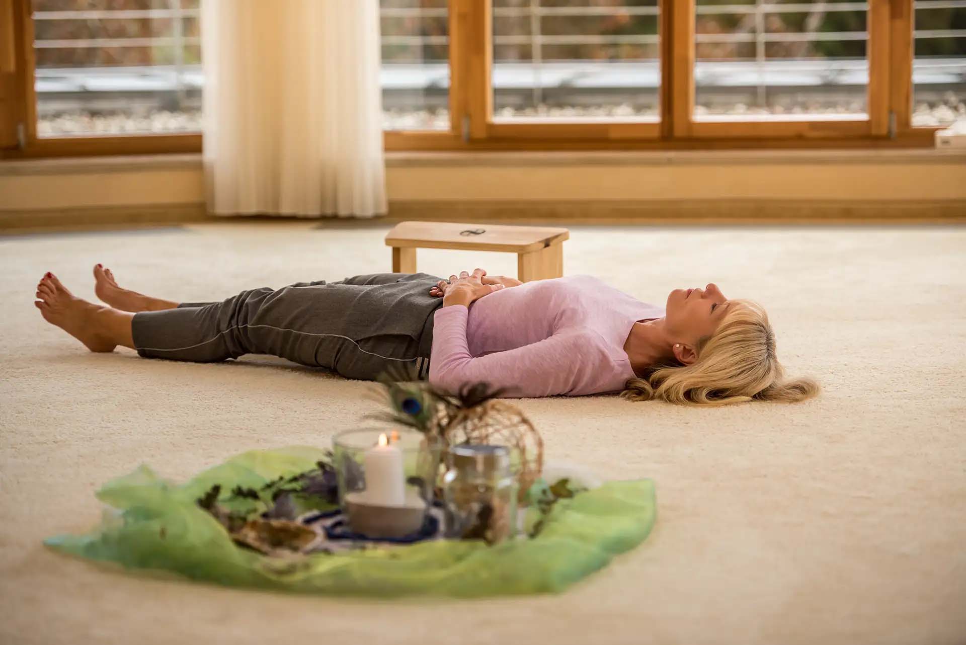 Frau liegt entspannt auf dem Boden während einer Achtsamkeitsübung. Bodyscan