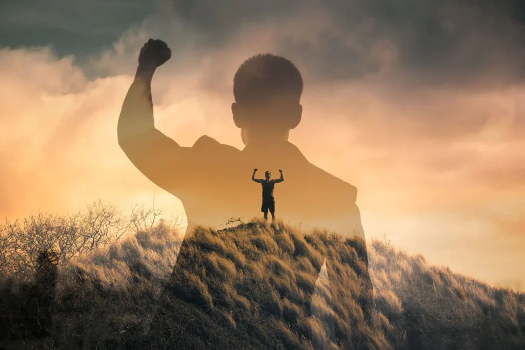 Silhouette eines Mannes, erhobene Faust, Triumph, Sonnenuntergang, Entschlossenheit, Stärke, Selbstverwirklichung.