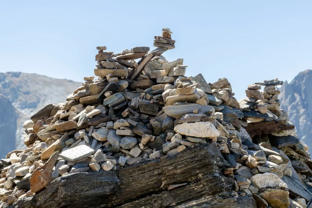 Ein Haufen Steine auf einem Berg, mit klarem Himmel im Hintergrund.