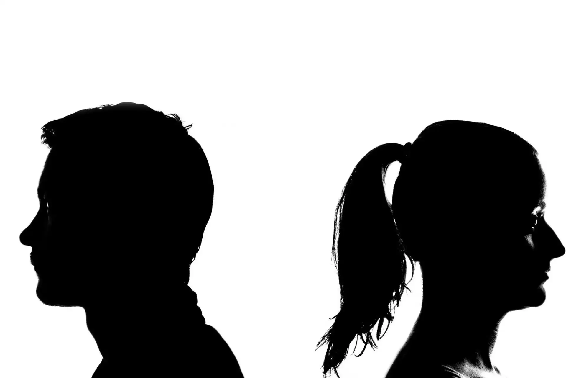 Zwei Silhouetten Rücken an Rücken, symbolisieren Konflikt oder Distanz.