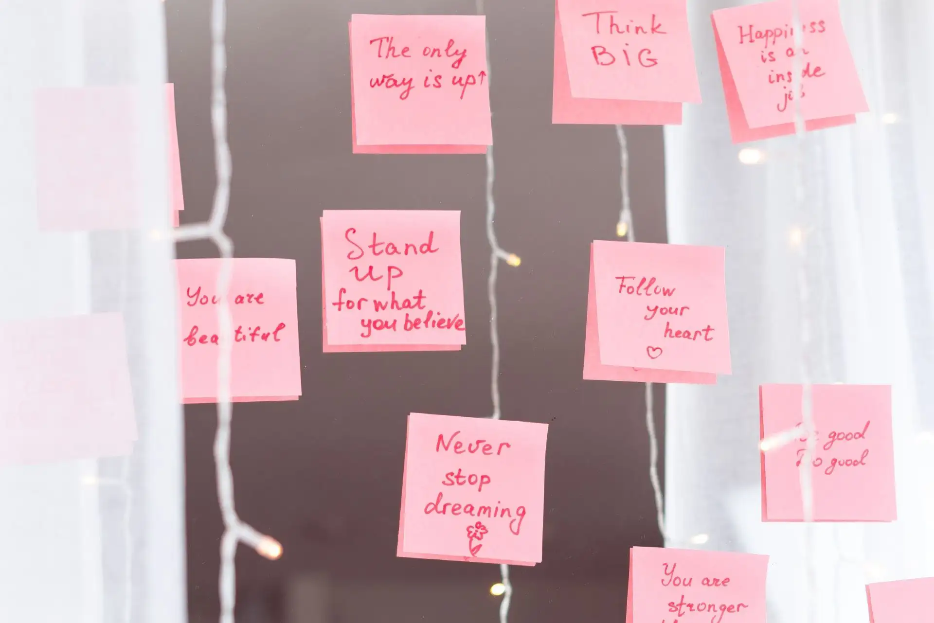 Einige pinke Notizen mit motivierenden Botschaften wie „Follow your heart“ und „Never stop dreaming“. Einige pinke Notizen mit motivierenden Botschaften wie „Follow your heart“ und „Never stop dreaming“. Einige pinke Notizen mit motivierenden Botschaften wie „Follow your heart“ und „Never stop dreaming“.