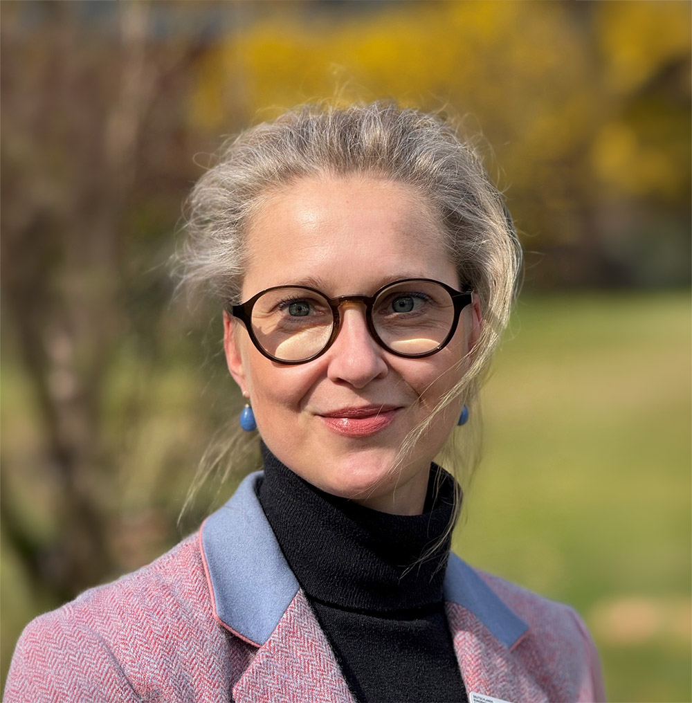 Frau mit Brille lächelt in die Kamera