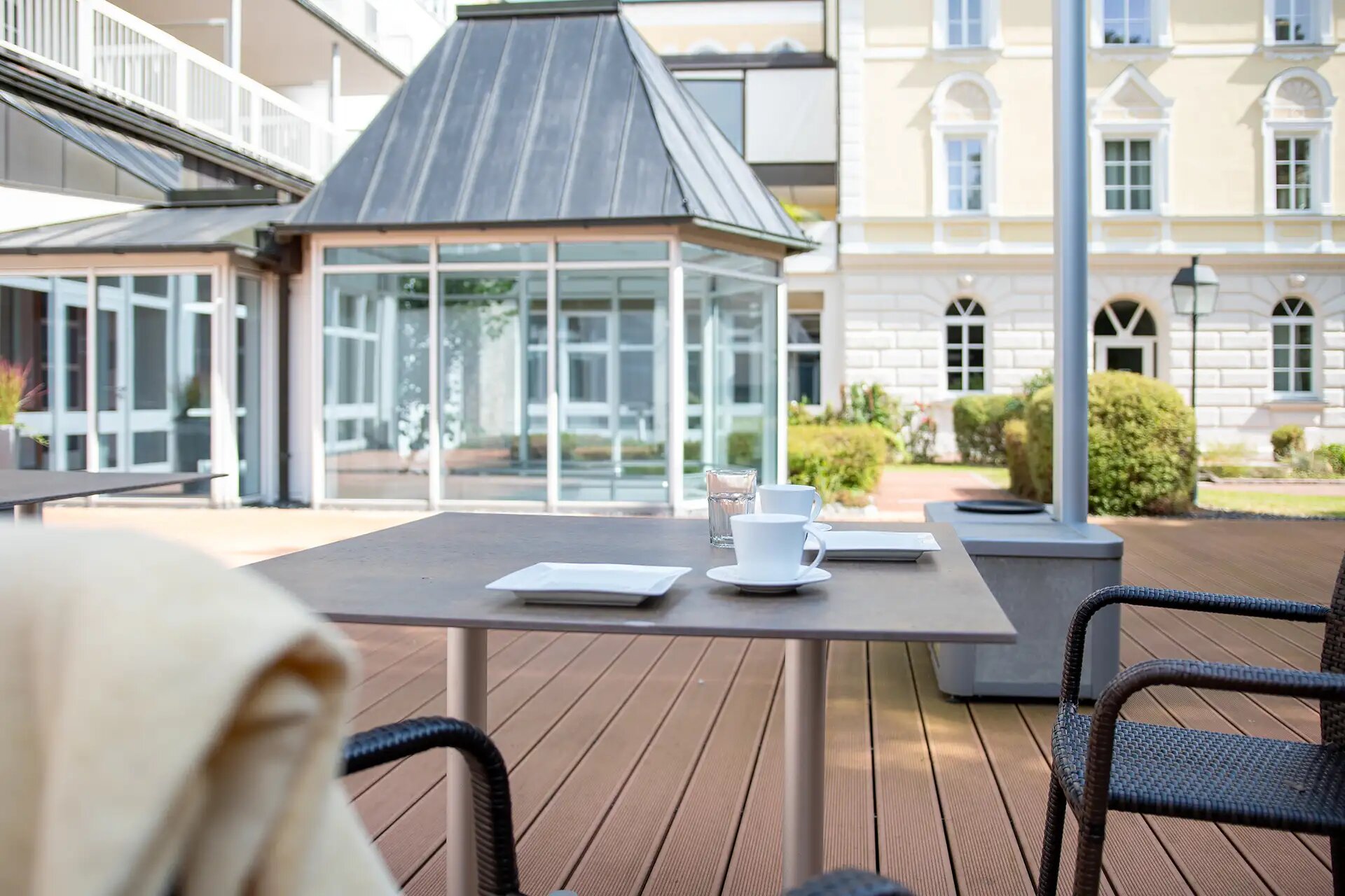 Sonnige Terrasse mit gedecktem Tisch in modernem Innenhof.