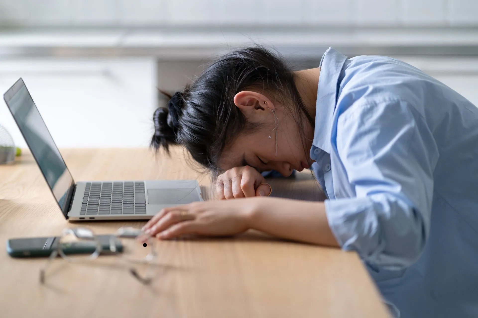 hochfunktionale depression - frau liegt mit dem kopf auf dem tisch