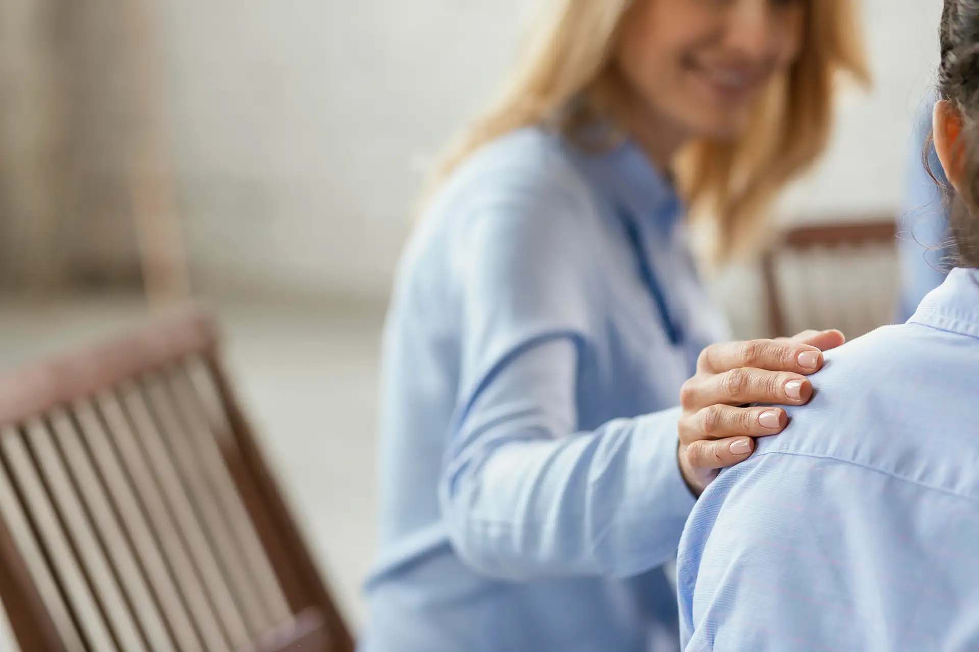 Eine Frau legt einer anderen Frau vertrauensvoll die Hand auf die Schulter