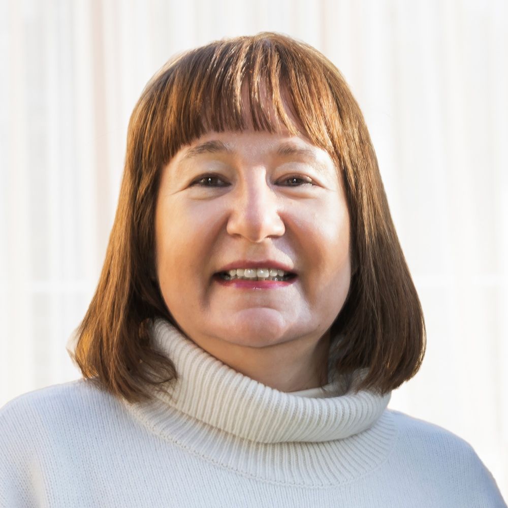 Eine Frau schaut lächelnd in die Kamera