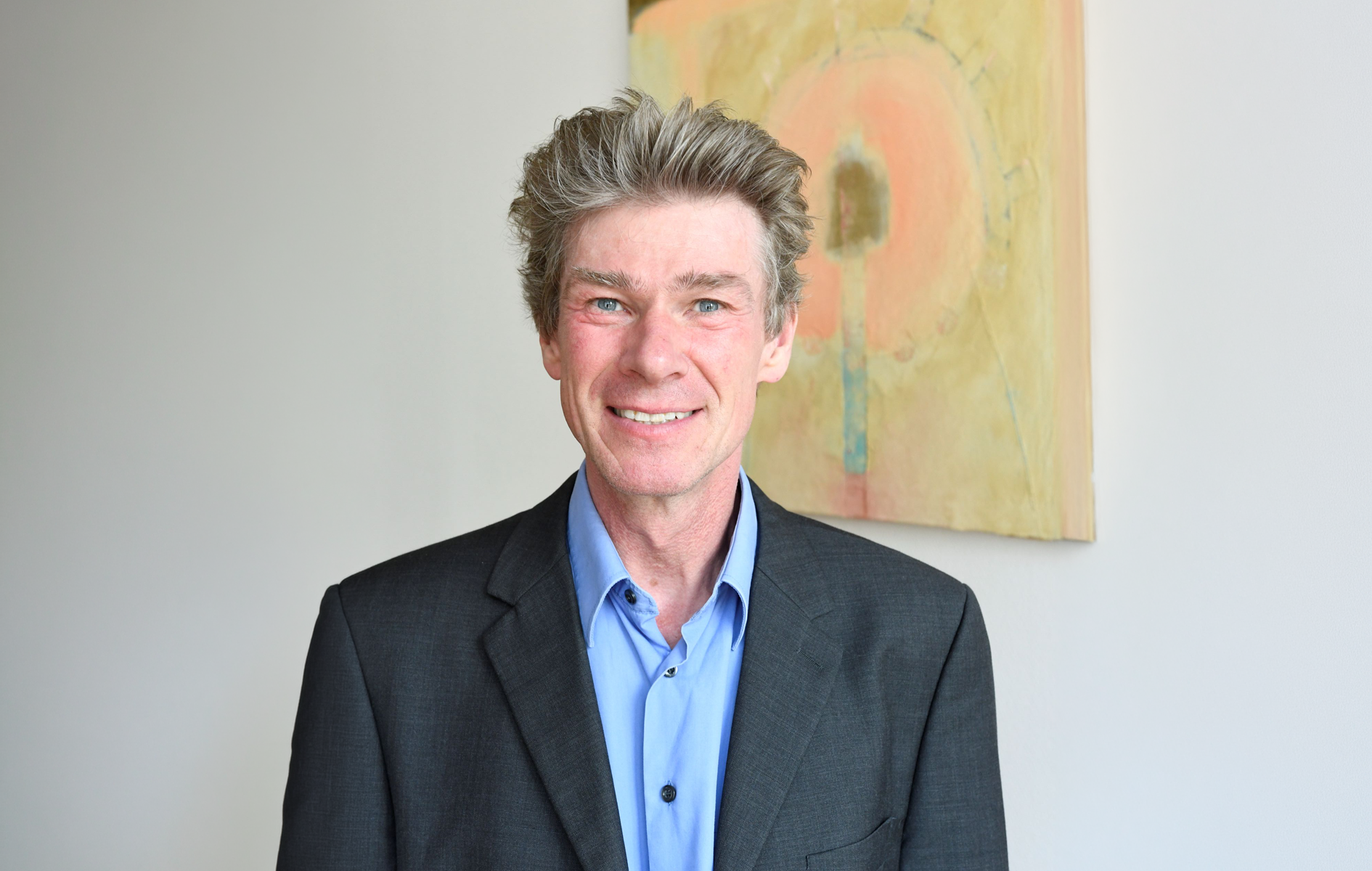 Lächelnder Mann in blauem Hemd.